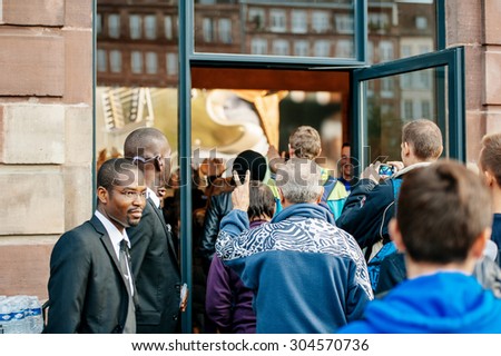 STRASBOURG, FRANCE - SEPTEMBER 19, 2014: Customer enters Apple Store with victory hand sign during the sales launch of the iPhone 6 and iPhone 6 Plus