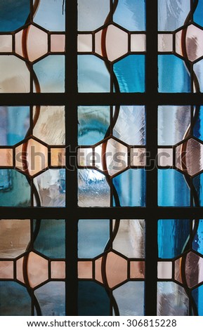 PARIS, FRANCE - FEBRUARY 10, 2015: Church corridor as seen through stained glass window with irregular block pattern in a hue of blue seen in Notre-Dame-de Paris Church