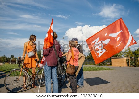 STRASBOURG, FRANCE - AUG 20, 2015: People protesting in front of European Parliament denouncing the Syrian airstrikes on Douma wheremore 80 were killed - people holding new anticapitalist party flag