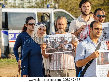 STRASBOURG, FRANCE - AUG 20, 2015: People protesting in front of European Parliament denouncing the Syrian airstrikes on Douma wheremore 80 were killed - holding war photography