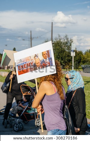 STRASBOURG, FRANCE - AUG 20, 2015: People protesting in front of European Parliament denouncing the Syrian airstrikes on Douma wheremore 80 were killed - Russia is the enemy placard