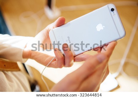 PARIS, FRANCE - OCT 3, 2015: Customer checks the back of the new iPhone 6s displayed at the Apple Store Opera