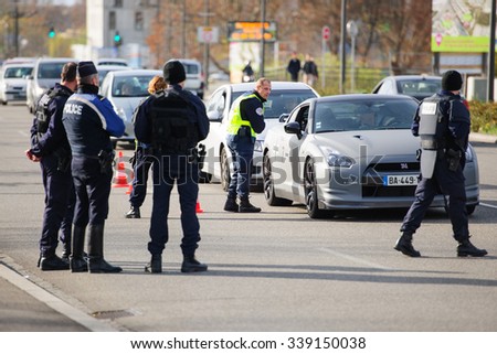 STRASBOURG, FRANCE - NOV 14 2015: French Police checking vehicles on the \'Bridge of Europe\' between Strasbourg and Kehl Germany, as a measure in the wake of attacks in Paris - officer inspecting car