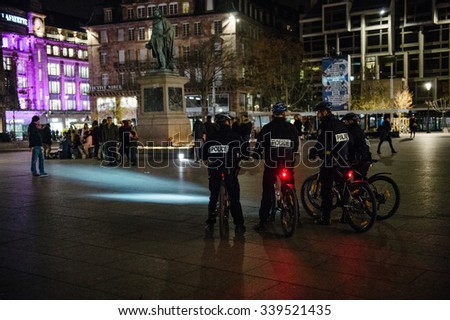 STRASBOURG, FRANCE - 14 NOV 2015: Police officers on bike looking at people and candles during a vigil in the center of Strasbourg for the victims of the November 13 attacks in Paris