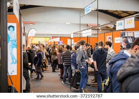 STRASBOURG, FRANCE - FEB 4, 2016: Children and teens of all ages attending annual Education Fair to choose career path and receive vocational counseling - rows of college stands
