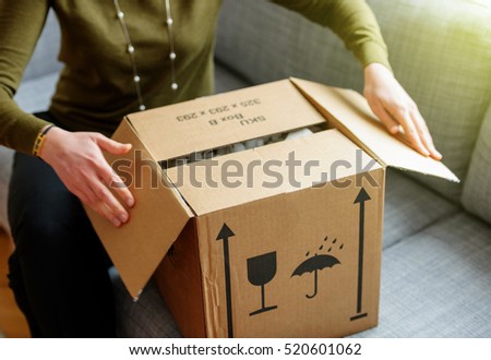 Woman unpacking unboxing cardboard carton box with protective foam pads inside after buying ordering online via internet a present good