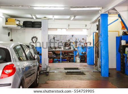 Garage service workshop with tools, hydraulic platform elevator, tools, equipment and car detail