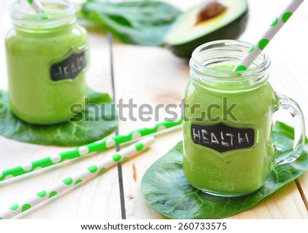Green vegetable smoothie isolated on wood background