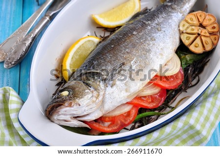 baked fish with herbs, vegetables and garlic, diet food. selective focus