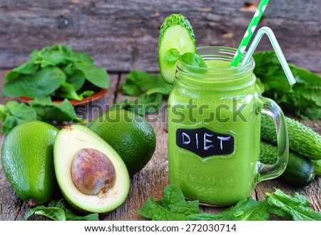 Green vegetable smoothie on wood background