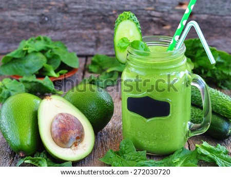 Green vegetable smoothie on wood background