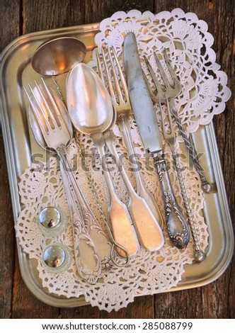 antiques - cutlery, spoons, forks, knives on a tray,  image is tinted