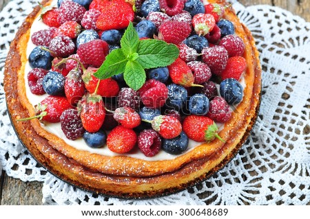 Cottage cheese casserole with fresh strawberries, blueberries, raspberries and mint and powdered sugar