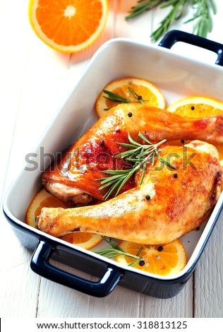 chicken leg roasted with olive oil, balsamic vinegar and soy sauce with orange slices, rosemary, pepper and sea salt