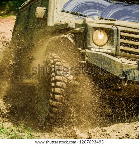Off-road travel on mountain road. Travel concept with big 4x4 car. Mud and water splash in off-road racing. Motion and power concept