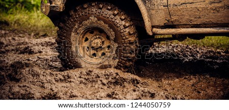 Getting off the beaten path. Car wheels on steppe terrain splashing with dirt. SUV or offroader on mud road. Car racing offroad. Offroad car in action. Dirty car drive on high speed.