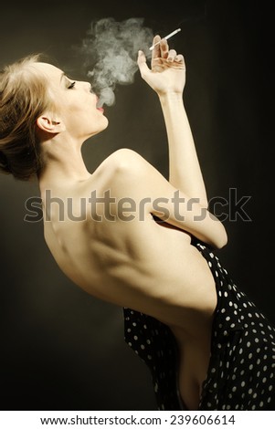 young girl with a bare back and beautiful figure smoking a cigarette