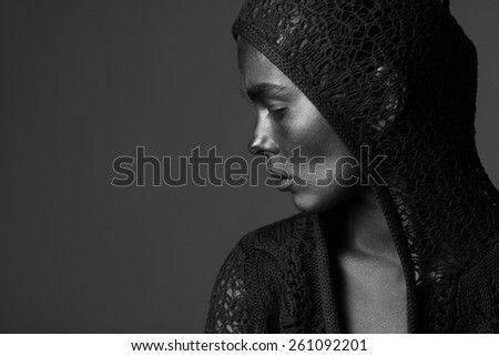 Portrait of woman painted with dark paint posing in studio