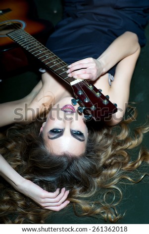 sensual blonde woman with shiny curly silky hair and guitar