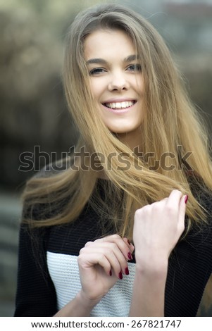 Portrait of a beautiful young woman with long hair looking forward, vertical photo