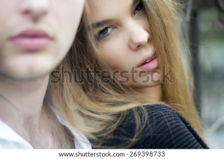 Sensual young woman looking forward with guy outdoor, horizontal picture