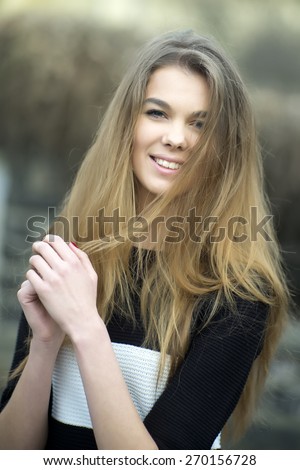 Portrait of a pretty young woman with long hair looking forward, vertical photo