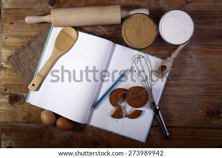 Set of ingredients and appliances for cooking with blank recipe book on wooden table top, horizontal picture