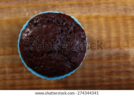 One chocolate cupcake on the table in blue silicone bakewares copyspace, horizontal photo