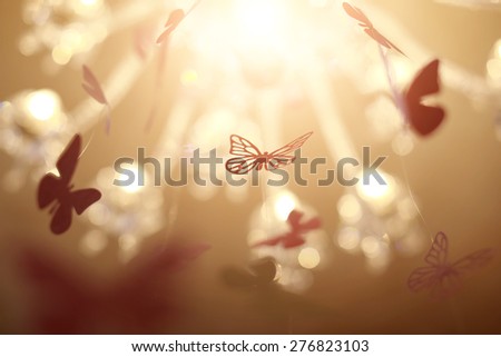 Beautiful small decorative butterflies hovering under the light, horizontal photo
