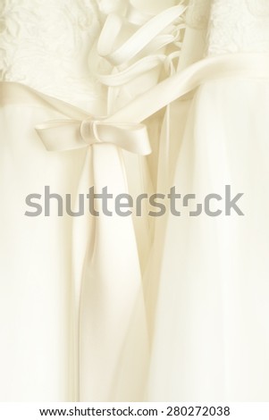Lace wedding dress ivory color and bow of beautiful ribbon, vertical picture