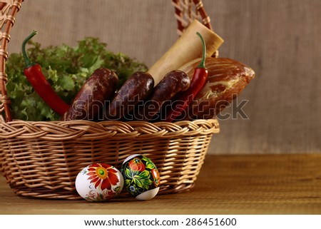 Meat home made tasty sausages lettuce bread rolls red pepper and easter eggs in basket, horizontal picture