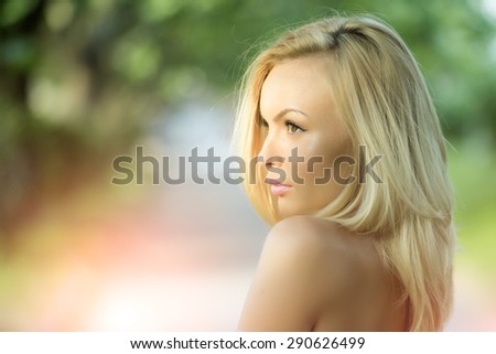 Portrait of pensive pretty blond girl outdoor in summer daylight on natural background copyspace, horizontal picture