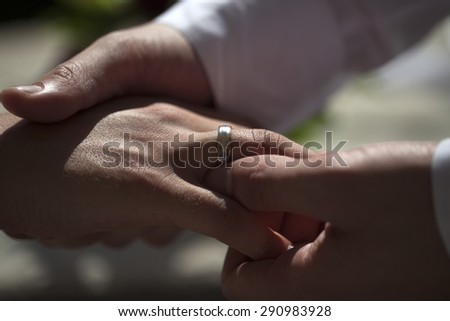 Married couple touching each other with hands and showing wedding ring on blur background closeup, horizontal picture