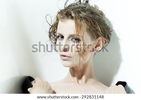 Portrait of sexy cool attractive slim woman with wet short hair looking forward standing on white background, horizontal picture