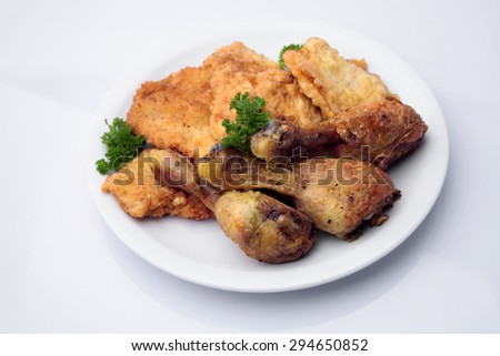 Restaurant food of delicious fried chicken drumsticks and breaded pork chops with golden crust decorated with parsley on plate isolated on white, horizontal picture