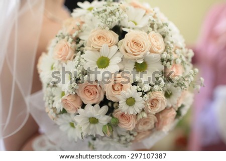 Closeup of beautiful wedding bunch of rose and chrysanthemum flowers pink orange, white colours with bride on blur background, horizontal picture