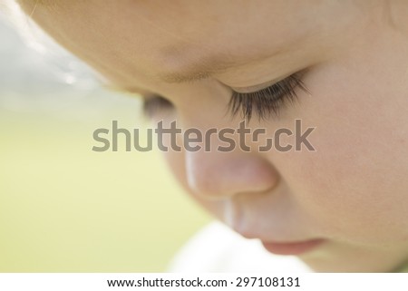 Portrait of small serious sweet baby boy with long eyelashes round cheeks and cute face closeup, horizontal picture