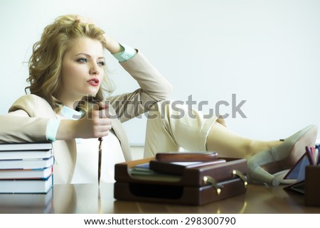 Pretty thoughtful sensual business woman sitting at table with many office appliances holding knife for cutting paper looking forward on white background copyspace, horizontal picture