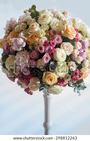 Adorning of wedding bouquet of fresh beautiful flowers of roses and peony white pink violet purple yellow lilac and orange colours in slim vase indoor, vertical picture