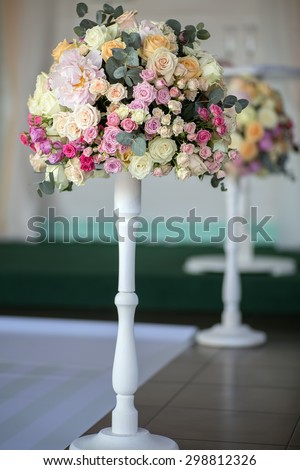 Decorate wedding bouquet of fresh beautiful flowers of roses and peony white pink violet purple yellow lilac and orange colours in slim long vase on tile floor background, vertical picture