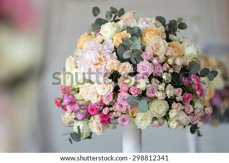 Decoration of wedding posy of fresh beautiful flowers of roses and peony white pink violet purple yellow lilac and orange colours in slim vase indoor, horizontal picture