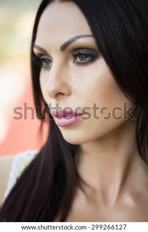 Portrait of beautiful sexy young girl with hard look bright makeup plump ripe lips long neck and black hair looking away closeup, vertical picture