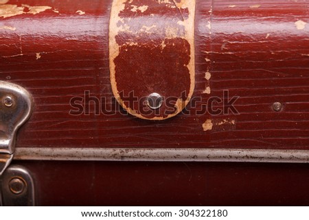 Closeup texture background of big old-fashioned aged brown leather briefcase with metal decoration in lying position copyspace, horizontal picture