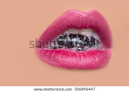 Closeup of sexual open female mouth of attractive young woman with foam beverage bubbles on bright pink lips on tan beige face, horizontal picture