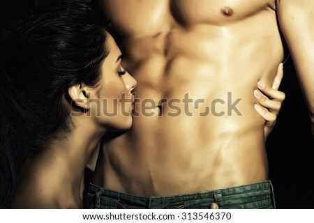 Closeup of undressed sensual pair of young brunette lady embracing and kissing man with beautiful muscular wet body with six-pack and abdoman, horizontal picture