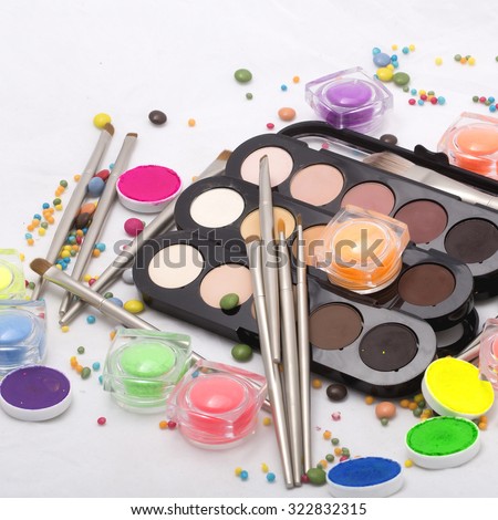 Set of many professional visagiste eyeshadow palette red orange green violet pink yellow purple black beige brown colors foundation powder and make-up brushes on white background, horizontal picture