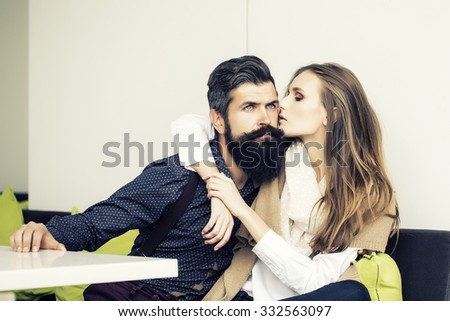 One beautiful stylish emotional couple of young woman and senior man with long black beard embracing sitting close to each other indoor in cafe, horizontal picture