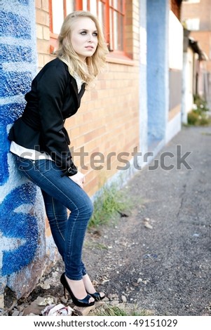 A young female fashion model in a woman\'s jacket and jeans.