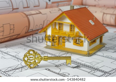 golden key and model house on construction plan