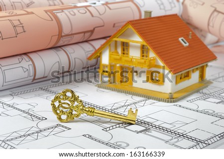 residential house and golden key over building plan